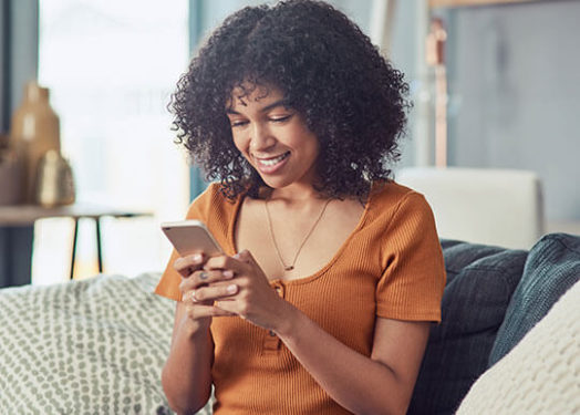 mujer enviando mensajes de texto en la sala de estar